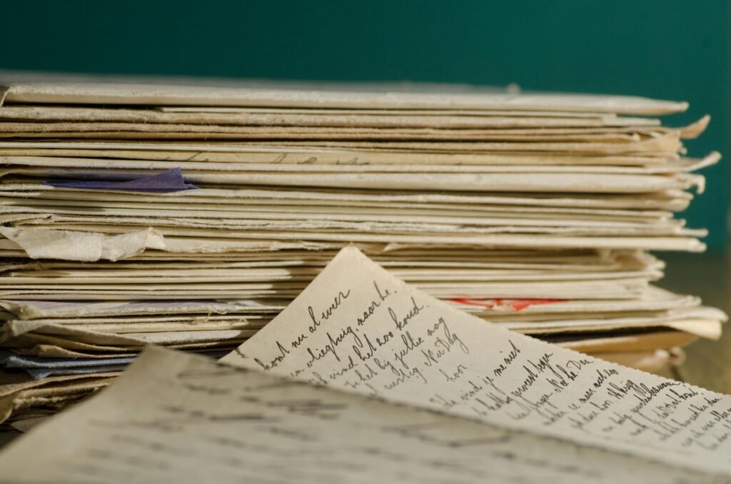 Close-up image of handwritten letters and papers stacked together, conveying a vintage feel.